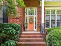 Inviting front entrance featuring a brick stairway, decorative wreath, and meticulously maintained landscaping at 15929 Northstone Dr, Huntersville, NC 28078