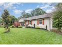 A charming home with lush green lawn, neat garden beds and classic architecture at 1621 Brookdale Ave, Charlotte, NC 28210