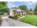 Well-maintained home featuring lush landscaping and a welcoming front entrance and fresh driveway at 1621 Brookdale Ave, Charlotte, NC 28210