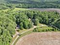 Aerial shot of property featuring multiple structures, open fields, and abundant trees at 169 Wilcox Karriker Ln, Statesville, NC 28625