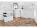 Open living room and kitchen area featuring stylish lighting, vaulted ceilings, and stainless appliances at 2104 County Line Rd, Kings Mountain, NC 28086