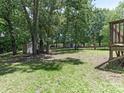 Large backyard with mature trees, a fire pit, and a storage shed at 2240 Lawton Bluff Rd, Charlotte, NC 28226