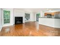 Bright living room featuring gleaming hardwood floors, fireplace, and a seamless transition to the modern kitchen at 2512 Cranbrook Ln # 9, Charlotte, NC 28207