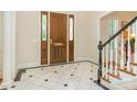 Foyer features marble floors, a wood door with sidelights and a staircase with white and black trim at 2516 Selwyn Ave, Charlotte, NC 28209