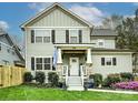 Traditional two-story home with green siding, black shutters, stone porch supports, and fresh landscaping at 2518 Pinckney Ave, Charlotte, NC 28205
