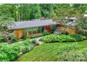 Aerial view of a brick home with a modern design, a well-maintained roof, and lush green surroundings at 2600 Cloister Dr, Charlotte, NC 28211