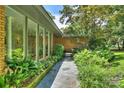Walkway leading to a modern home entrance, surrounded by lush greenery and natural light at 2600 Cloister Dr, Charlotte, NC 28211