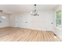 Spacious living room featuring luxury vinyl floors, modern light fixture, and a view of the front entrance at 406 N Bostian St, China Grove, NC 28023