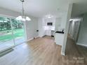 Bright kitchen featuring new stainless steel appliances, white cabinetry, and a sliding glass door to the backyard at 4209 Donnybrook Pl, Charlotte, NC 28205