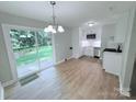 Bright kitchen featuring new stainless steel appliances, white cabinetry, and a sliding glass door to the backyard at 4209 Donnybrook Pl, Charlotte, NC 28205