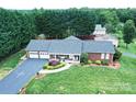 Stunning aerial view of a brick home with a lush green lawn, long driveway, and mature trees at 4646 River Run Cir, Hickory, NC 28602