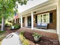Welcoming front porch featuring brick accents, comfortable seating, and a classic American flag display at 4925 Cedar Forest Dr, Charlotte, NC 28226