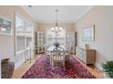 Bright dining room with a chandelier, hardwood floors, and large windows at 499 Granite Lake Ct, Denver, NC 28037