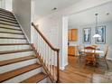 View of the staircase with wooden treads and white risers, leading to a dining area with wood floors at 513 Pate Dr, Fort Mill, SC 29715
