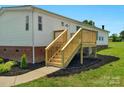 Freshly built wooden front porch, new siding, and landscaping enhance this lovely home's curb appeal at 5606 S Rocky River Rd, Monroe, NC 28112