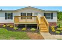 The exterior features a new wooden porch, siding, and fresh landscaping at 5606 S Rocky River Rd, Monroe, NC 28112