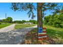View of the long driveway leading to the home on a grassy lot with mature trees at 5606 S Rocky River Rd, Monroe, NC 28112