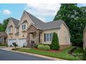 Inviting home with stone porch, two car garage, and manicured landscaping, set beneath a blue sky at 5917 Bridger Ct, Charlotte, NC 28211