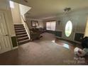 Inviting living room with carpet, staircase, front door and comfortable furnishings at 6120 Brightstar Valley Rd, Mint Hill, NC 28227