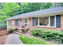 Stylish brick home featuring updated windows, a well-manicured lawn, and inviting front entrance at 6626 Rocky Falls Rd, Charlotte, NC 28211