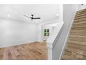 Bright living room featuring hardwood floors, staircase, white walls, ceiling fan and natural light at 7874 Lucky Creek Ln, Denver, NC 28037