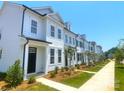 Row of charming white townhouses with black doors and window trim, plus sidewalks and lawn at 8102 Jacey Ln # 24, Huntersville, NC 28078