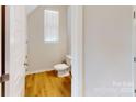 Bathroom features a toilet and window, plus light-toned wood-look floors at 8122 Jacey Ln # 19, Huntersville, NC 28078