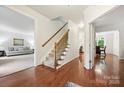 Open hallway with hardwood floors, staircase, and views into the living and dining rooms at 8217 Lansford Rd, Charlotte, NC 28277
