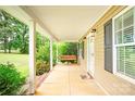 Inviting covered front porch with a swing, offering a relaxing outdoor space at 8622 Lower Rocky River Rd, Concord, NC 28025
