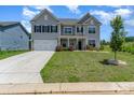 Charming two-story home boasts a manicured lawn, inviting entrance, and a two-car garage at 10045 Carousel Corral Dr, Midland, NC 28107