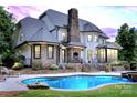 Beautiful backyard with a luxurious pool and a stone patio, perfect for entertaining and relaxation with a beautiful home at 106 Kent Ct, Mooresville, NC 28117