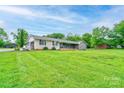 Expansive front yard showing a brick and stone home with an attached garage on a lush green lawn at 111 Gordon Ave, Shelby, NC 28152