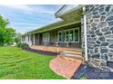 Inviting front porch with stone accents and brick stairs leading up to a charming seating area at 111 Gordon Ave, Shelby, NC 28152