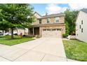 Charming two-story brick home with a covered front porch and attached two-car garage at 12923 Plumleaf Dr, Charlotte, NC 28213