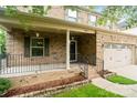 Inviting covered front porch with brick foundation, black railings, and a welcoming entryway at 12923 Plumleaf Dr, Charlotte, NC 28213
