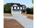 Charming two-story home with black roof, white siding, and attached garage at 1308 Austin Chaney Rd, Wingate, NC 28174