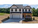 New two-story home with white siding, stone accents, covered entry, and a large concrete driveway at 1308 Austin Chaney Rd, Wingate, NC 28174