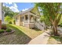 Inviting yellow home with a charming porch and lush green lawn, perfect for relaxed outdoor living at 14105 Garden District Row, Huntersville, NC 28078