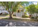 Charming yellow home with a large porch, perfect for enjoying the outdoors in a quiet neighborhood at 14105 Garden District Row, Huntersville, NC 28078
