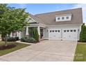 Charming home with a two-car garage, complemented by mature landscaping, and a welcoming front porch at 16034 Rushwick Dr, Huntersville, NC 28078