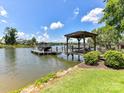 Picturesque waterfront scene featuring a private dock with a covered area, perfect for enjoying lake views at 164 Twin Sisters Ln, Mooresville, NC 28117