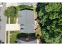 Aerial shot of a home featuring a deck, green lawn, and a long driveway nestled among lush trees at 20324 Middletown Rd, Cornelius, NC 28031