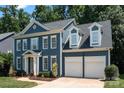 Charming two-story blue home with a welcoming front porch, attached two-car garage, and well-maintained landscaping at 20324 Middletown Rd, Cornelius, NC 28031