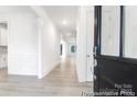 Bright entryway featuring light wood floors and white wainscoting, leading to an open-concept living space at 236 Wheatfield Dr # 102P, Statesville, NC 28677