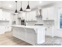 Modern kitchen with white cabinets, stainless steel appliances, a spacious island, and stylish pendant lighting at 236 Wheatfield Dr # 102P, Statesville, NC 28677