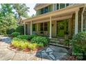 Inviting front porch with stone walkway, lush landscaping, and a charming green front door at 258 Patterson'S Bridge None, New London, NC 28127