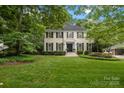 Charming two-story home with a manicured lawn, mature trees, and traditional brick architecture at 2709 Wamath Dr, Charlotte, NC 28210