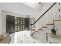 Bright foyer with marble floors, a grand staircase with white spindles, and elegant double doors at 2709 Wamath Dr, Charlotte, NC 28210