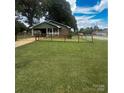 Charming home features a well-manicured lawn, surrounded by a neat fence under a partly cloudy sky at 300 N Watterson St, Kings Mountain, NC 28086
