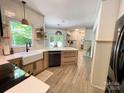 Bright kitchen featuring quartz countertops, stainless steel appliances, farmhouse sink, and wood-look tile floors at 3314 Mara Ct, Matthews, NC 28105